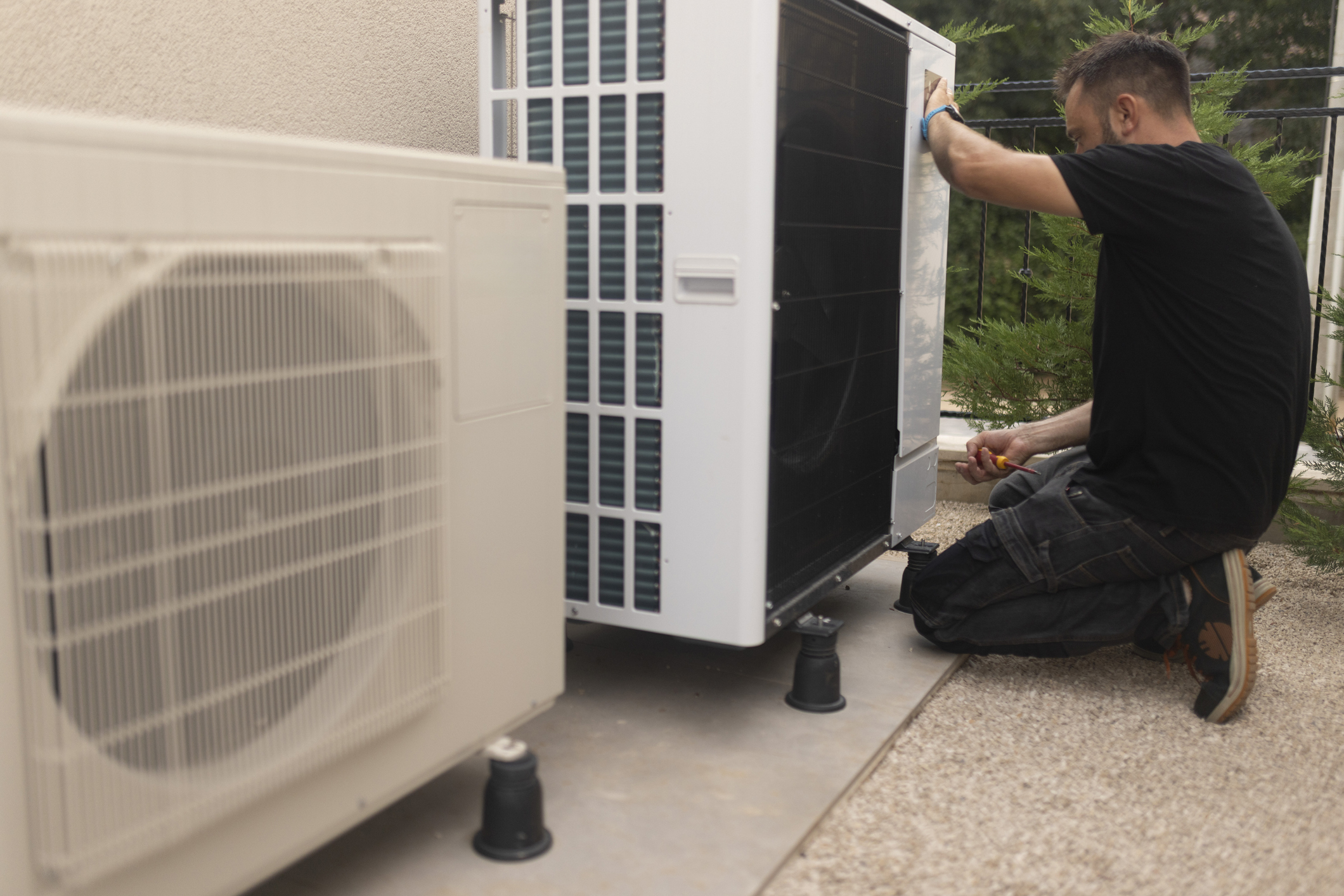 A man installing a heat pump